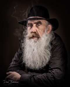 portret van karakteristieke man met hoed grote baard en sigaar