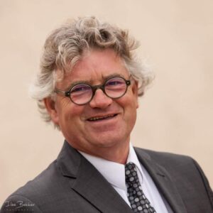 zakelijk portret van enthousiaste ondernemer tegen taupe achtergrond