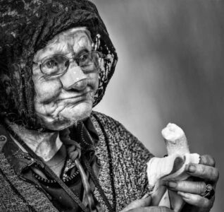 portretfotografie prachtig karakteristiek beeld van oude vrouw met geheel eigen persoonlijkheid die een banaan eet