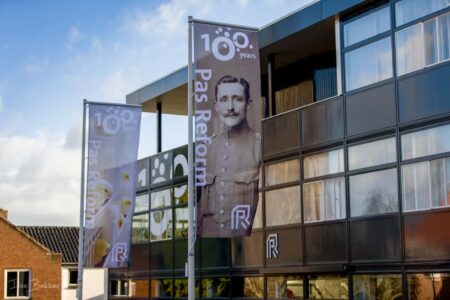 afbeelding van het pand pas reform Zeddam met vlaggen 100 jarig bestaan