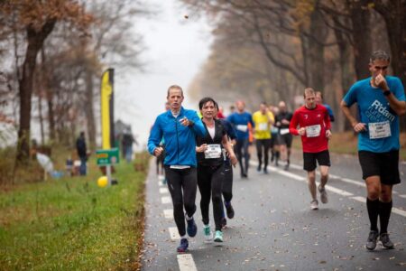 evenementfotografie Montferlandrun rennend door de regen is deze renner nog alert als hij de fotograaf opmerkt en maakt een gebaar van ik kom er aan