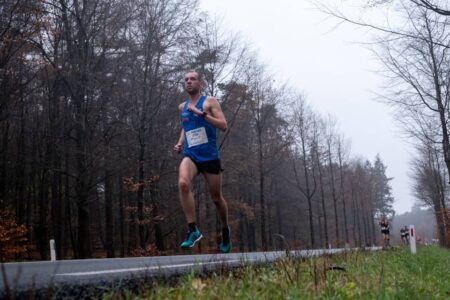 evenementfotografie Montferlandrun renners lopen in regenachtig weer over verharde weg en de afstand tussen de renners wordt groter