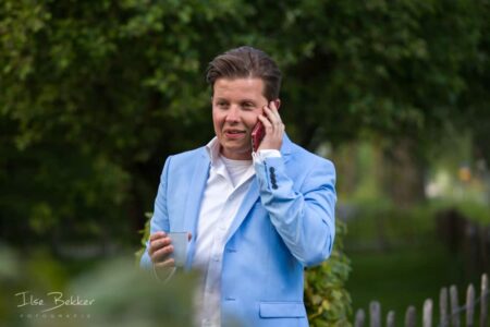 zakelijk portret van succesvolle jonge zakenman gefotografeerd op een buitenlocatie bellend met een relatie terwijl hij een kop koffie in zijn andere hand vasthoudt