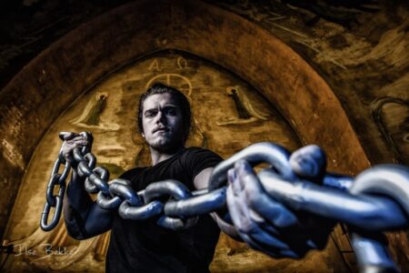 portretfotografie jonge sporter met zware ketting bijzondere manier van fitness in de kapel van het voormalig juvenaat zevenaar