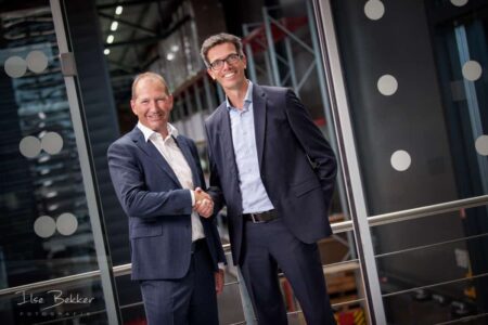 zakelijke fotografie_twee zakenmensen schudden elkaar de hand in een ontspannen sfeer