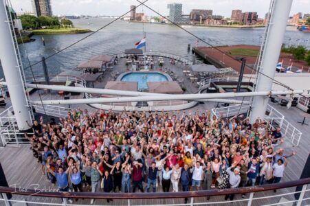groepsfoto van alle personeelsleden van pas reform gemaakt op het dek van de ss Rotterdam tijdens 100 jarig feest
