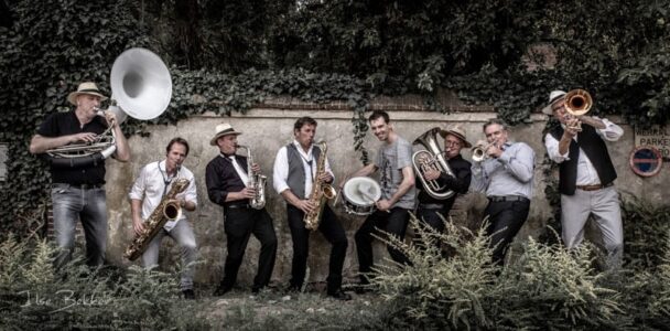 zakelijke foto van mbrassband spelend op hun instrumenten voor oude muur in sheerenberg